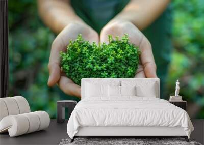 Concept of environmental stewardship and care for our planet It shows hands gently cupping a heart-shaped arrangement of lush,verdant foliage Wall mural