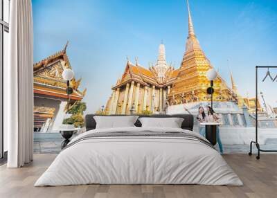  women friends enjoy sightseeing while travel in temple of the emerald buddha in Thailand Wall mural