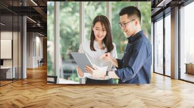 Asian businessman and woman discussing new business project Wall mural