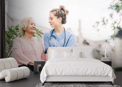 caregiver holding hand of happy elderly woman Wall mural