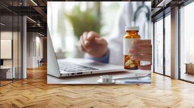 Close-up of the doctor's hand holding a bottle of pills near a laptop computer and a stethoscope lying on a clipboard medical documents on a desk in a clinic office. prescribe concept. Wall mural