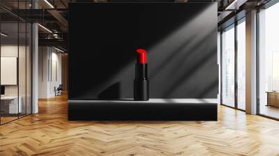 Red lipstick is isolated on a matte background, with a monochromatic color palette and soft backlighting. The bottle is placed on a smooth, dark surface. Makeup product. Wall mural