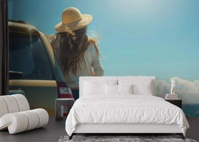 Young woman in straw hat standing against car and looking at sea view from a high cliff, Travel concept for a summer vacation or holiday trip with young people in the vehicle in the style of sea. Wall mural