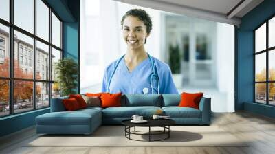 Portrait of confident, happy female nurse in hospital hallway Wall mural