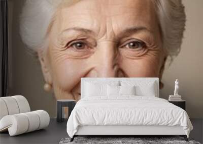 Close-up portrait of smiling senior caucasian woman with white hair and beige sweater against neutral background Wall mural