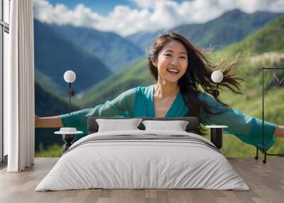 Young woman wearing green dress smiles with arms outstretched in rolling hills Wall mural