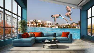 Two men jumping in swimming pool Wall mural