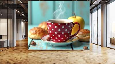 A red polka dot mug with hot tea, a yellow apple, and two pastries on a teal blue wooden background Wall mural