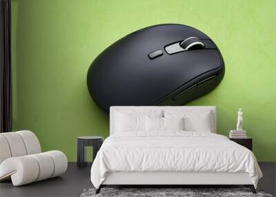 A sleek, black computer mouse placed against a vibrant green background Wall mural