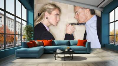 angry businesswoman pulling man's tie Wall mural