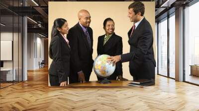 corporate businesspeople standing around world globe. Wall mural