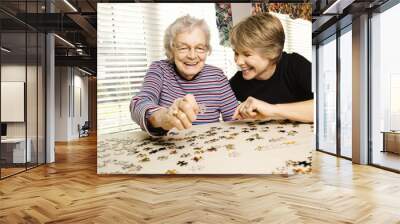 Elderly Woman and Younger Woman Doing Puzzle Wall mural