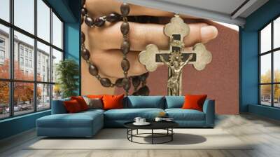 Woman holding Holy Bible open with rosary. Wall mural