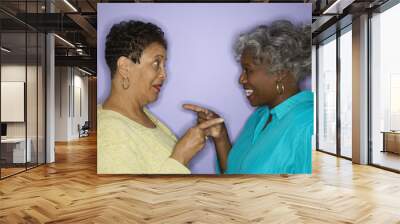 Women pointing at eachother. Wall mural