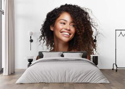 Joyful woman with curly hair and a captivating smile on a dark background Wall mural