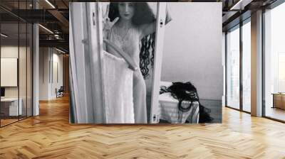 creepy young woman with long curly hair in scary room Wall mural