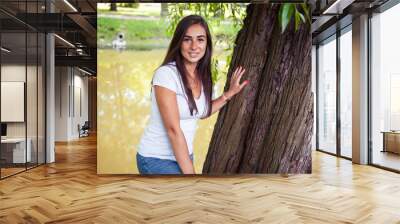 pretty young woman smiling cheerful in green park at tree on summer sunny day, lifestyle people concept Wall mural