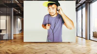 young asian man in hat and headphones listening music on white b Wall mural