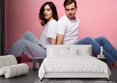 young cheerful caucasian couple together having fun on pink background, guy ang girl modern relationship, lifestyle people concept Wall mural