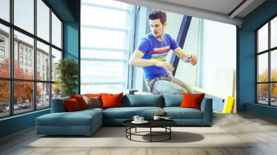 young handsome man doing parkour in gym inside, lifestyle sport people concept Wall mural