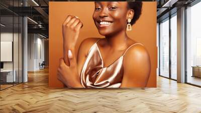 young pretty african model with golden jewelry in fashion style dress smiling happy on brown backround, lifestyle people concept Wall mural