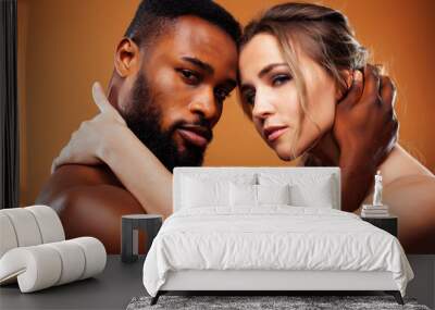 young pretty couple diverse races together posing sensitive on brown background, lifestyle people concept Wall mural