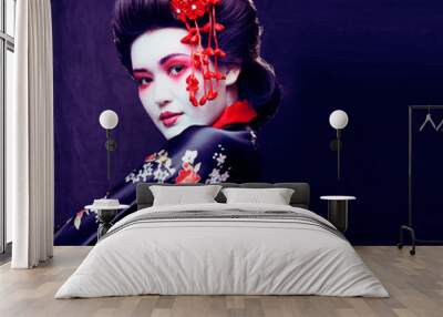 young pretty real geisha in kimono with sakura and decoration on black background Wall mural