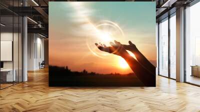 .Woman hands praying for blessing from god on sunset background Wall mural