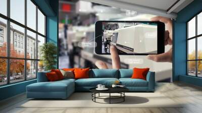 Augmented reality concept. AR. Industrial 4.0 , Hand of engineer holding mobile smart phone using virtual AR to check the work of electric machine on smart factory background. Wall mural