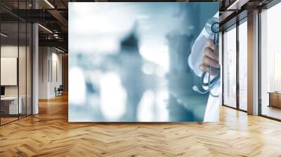 doctor with stethoscope in hand on hospital background, medical and medicine concept Wall mural