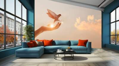 Woman praying and free bird enjoying nature on sunset background, hope concept Wall mural