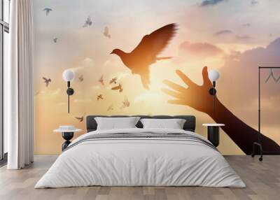 Woman praying and free the birds flying on sunset background, hope concept Wall mural