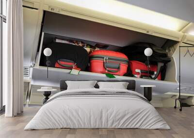 Cabin luggage inside overhead stowage compartment of an airplane Wall mural