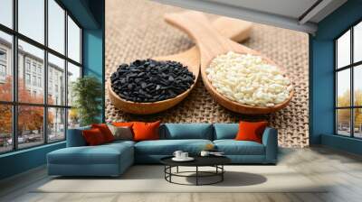 Black sesame and white sesame seeds on wooden spoon Wall mural