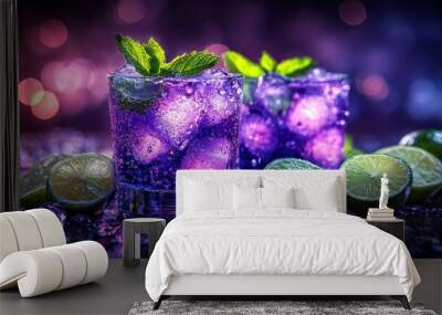 Two glasses of purple cocktail with lime wedges and mint leaves on a dark background. Wall mural