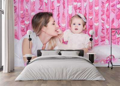 Portrait of mother with daughter in a festive pink interior Wall mural