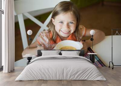 Little girl having lunch and eating soup Wall mural