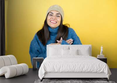 Young beautiful woman wearing blue casual sweater and wool hat smiling with her hands on her chest and grateful gesture on her face. Wall mural