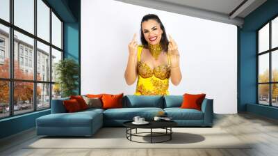 Young beautiful woman wearing carnival costume over isolated white background showing middle finger doing fuck you bad expression, provocation and rude attitude. screaming excited Wall mural