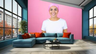 Young beautiful woman wearing pink headscarf over isolated pink background with a happy face standing and smiling with a confident smile showing teeth Wall mural