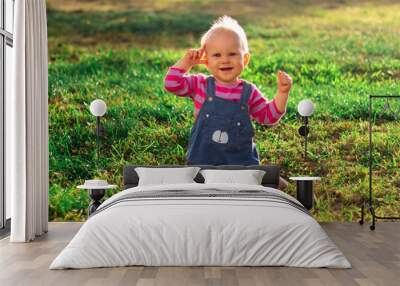 A Cute Baby Delightfully Having Fun While Enjoying Nature and Playing in the Warm Sunshine Wall mural