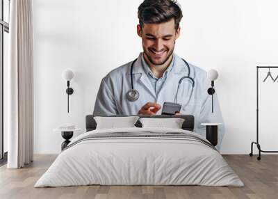 Cheerful young doctor in white coat smiling while looking at screen of his phone on isolated transparent background Wall mural