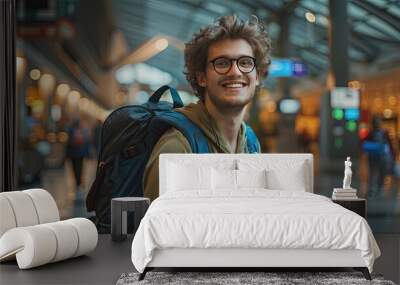 Portrait of a happy young man solo traveler with a backpack inside an airport terminal , backpacker going to an new adventure concept image with copy space Wall mural