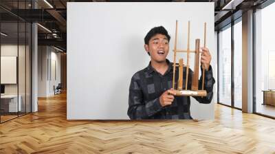 Indonesian men hold angklung. Angklung is a traditional musical instrument in Sundanese society. This instrument is made of bamboo, sounded by shaking Wall mural