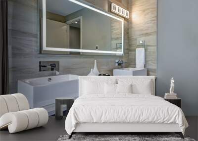 Contemporary bathroom interior with beige ceramic tiles, luxury details, huge light up mirror and two sinks.  Wall mural