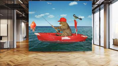 A beige cat fisherman in a red row boat caught a gold fish in the sea. Wall mural