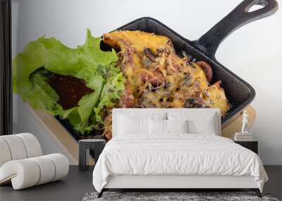 Baked meat with potatoes and mushrooms under melted cheese with salad and sauce in metal pan on wooden board on white background Wall mural