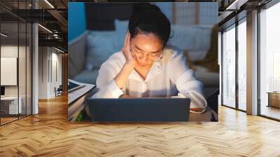 Asian female businesswoman, student or employee is sleeping while working on desk. Concept of exhausted from deadline work, overwork document or overtime late at night. Manager tired of midnight job. Wall mural