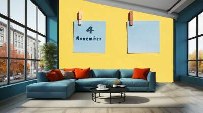 4 november. 4th day of the month, calendar date. Two blue sheets for writing on a yellow background. Top view, copy space. Autumn month, day of the year concept Wall mural