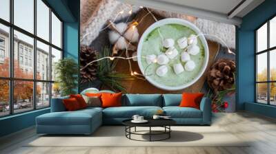 A cup of fragrant and tasty green matcha latte coffee decorated in a Christmas style. Wall mural